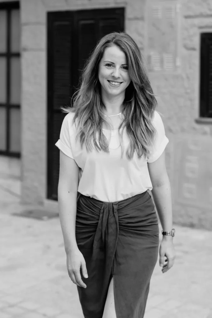 schwarz-weiß Foto von Zeitmanagement Mentorin Julia Leifheit mit lächelndem Blick in die Kamera